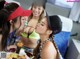 A group of young women sitting around a table eating food.