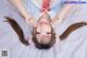 A woman laying on top of a bed with her hands on her head.