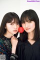 Two young women posing for a picture with a red balloon.