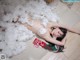 A naked woman laying on the floor covered in fluffy white cotton.