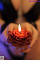 A person holding a red rose in their hands.