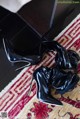 A pair of black high heels sitting on top of a rug.