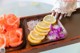 A tray of lemons and flowers on a table.