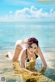 A woman in a black bikini laying in the water.