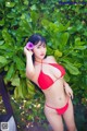 A woman in a red bikini posing for a picture.