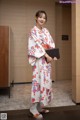 A woman in a kimono holding a book in her hands.