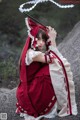 A woman in a red and white dress holding an umbrella.