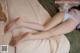 A woman laying on top of a bed with her legs crossed.