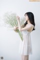 A woman in a white dress holding a bunch of flowers.