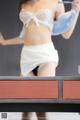 A woman in a white lingerie is playing ping pong.